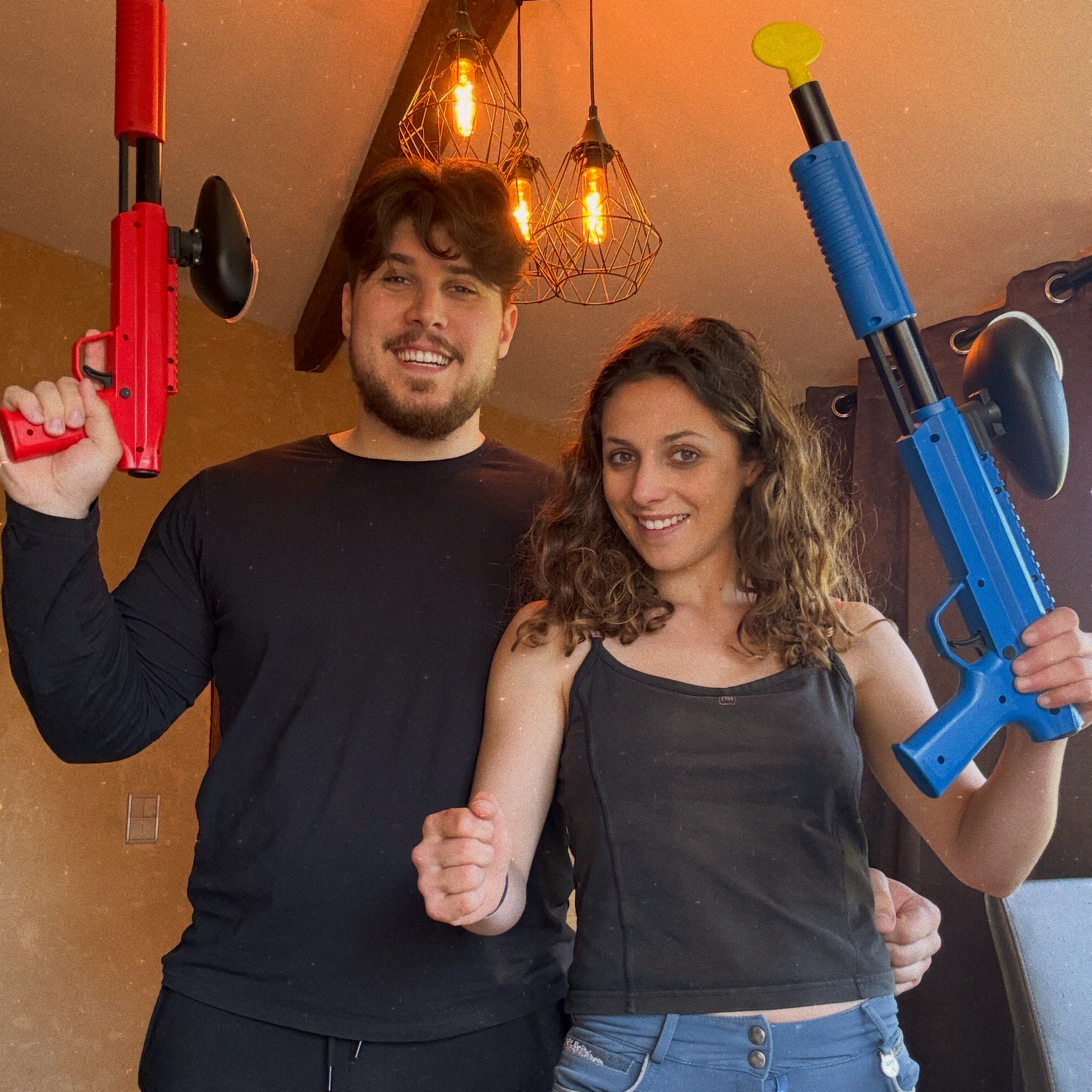 Couple tenant des lanceurs de paintball avant une partie sur les terrains de La Confrérie en Dordogne.