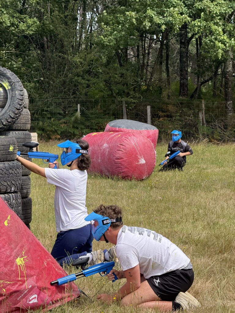 Jeunes joueurs participant à une partie de paintball sur terrain gonflable en Dordogne.