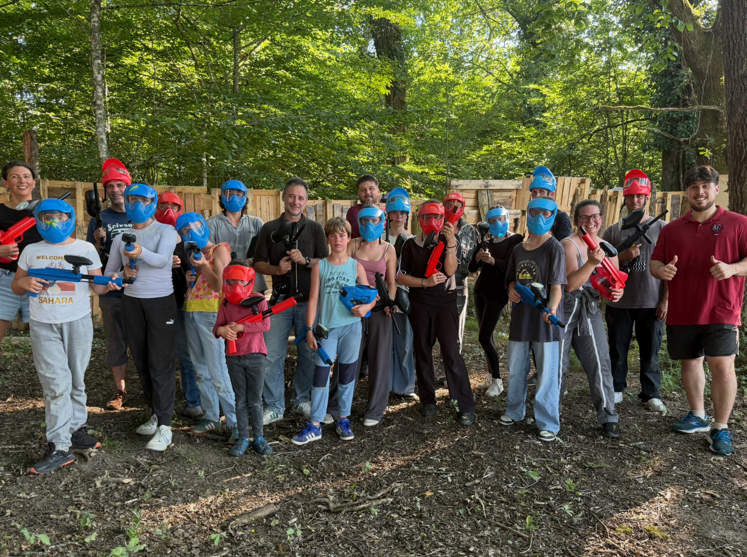 Famille et groupe d’amis réunis après une partie de paintball en forêt en Dordogne.
