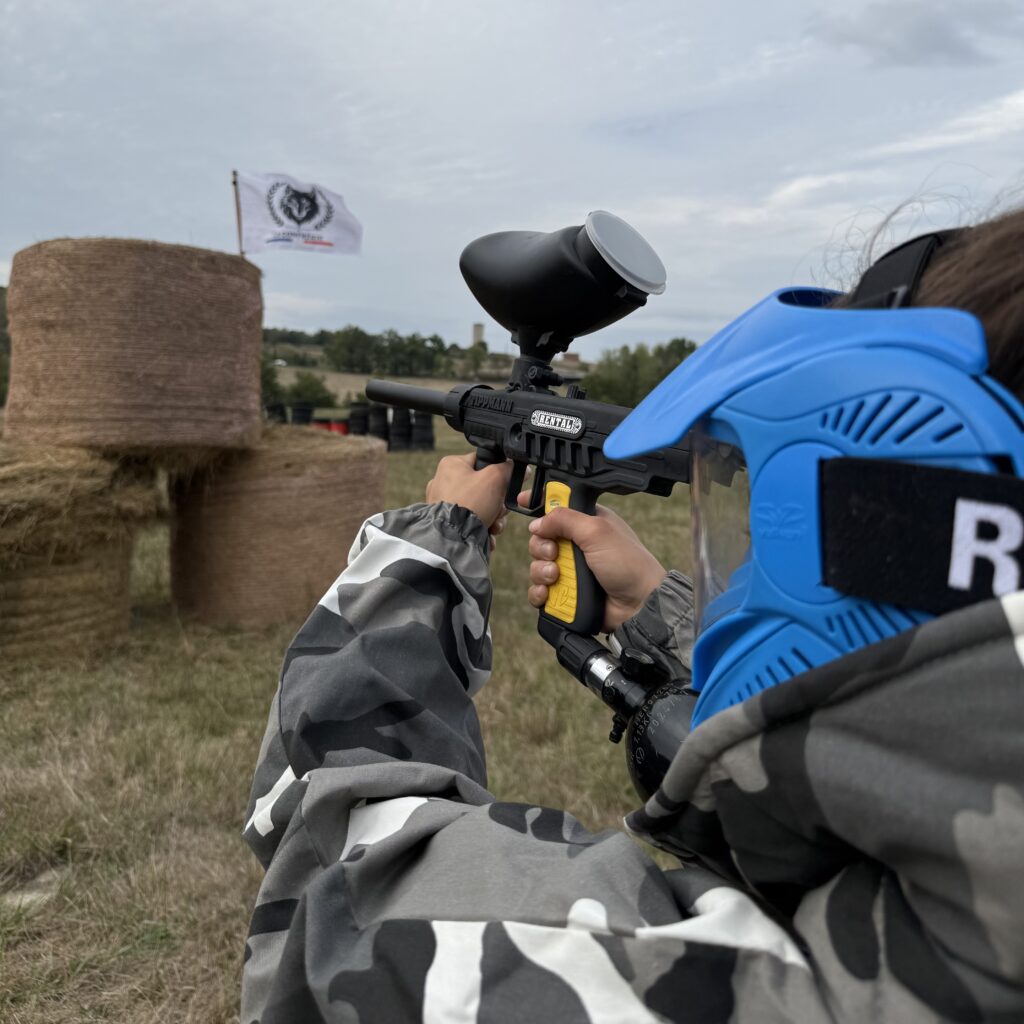 Jeune joueur de paintball visant une cible sur le terrain La Confrérie en Dordogne.