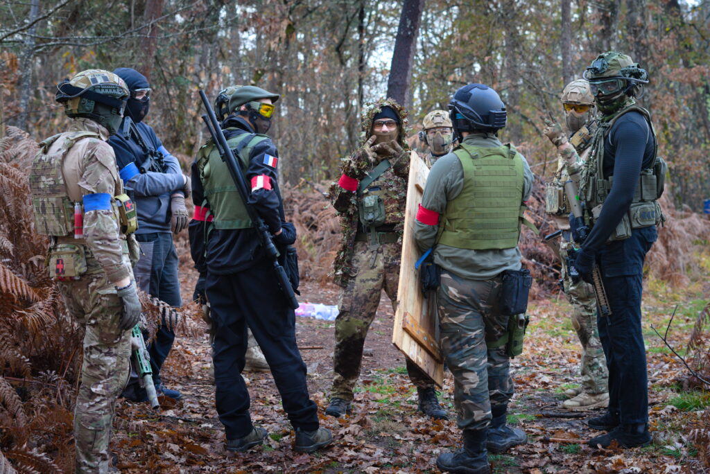 Équipe de joueurs d’airsoft préparant une mission tactique en forêt lors d’un scénario immersif en Dordogne.